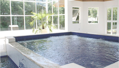 Piscina menor em ambiente coberto com janelas